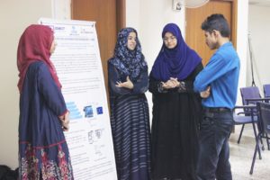 Students at IEEE SZABIST Hyderabad Student Branch Innofest 17 presenting their poster to a judge